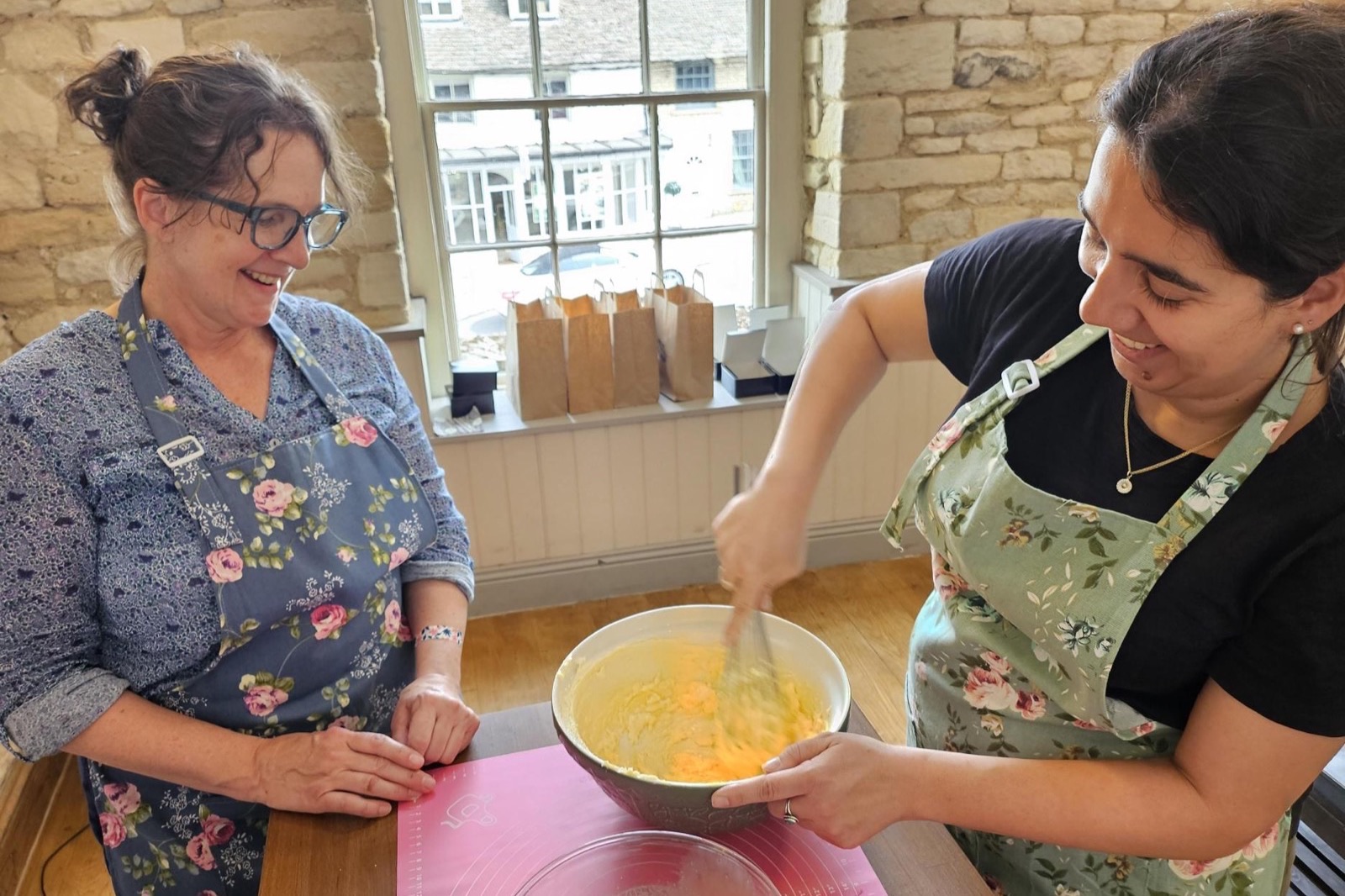 Two guests mixing cake batter in the Burford baking studio