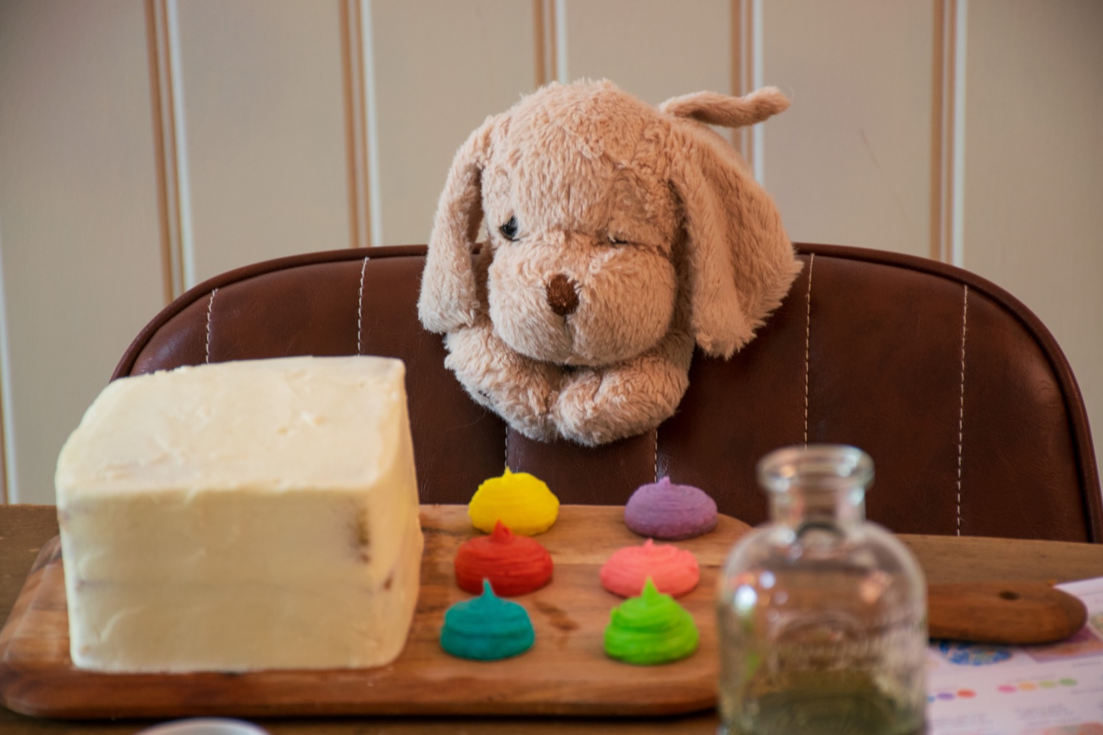 An iced cake and colourful icing beside a toy rabbit