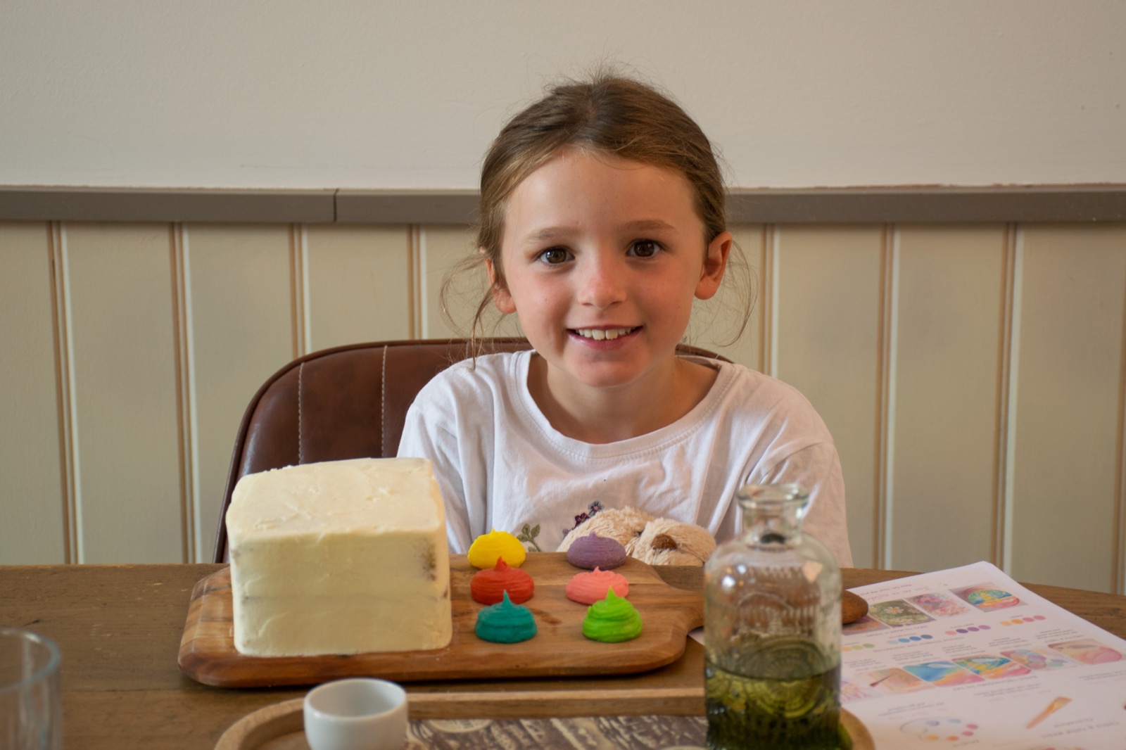 A young guest with a small iced cake and colourful icing