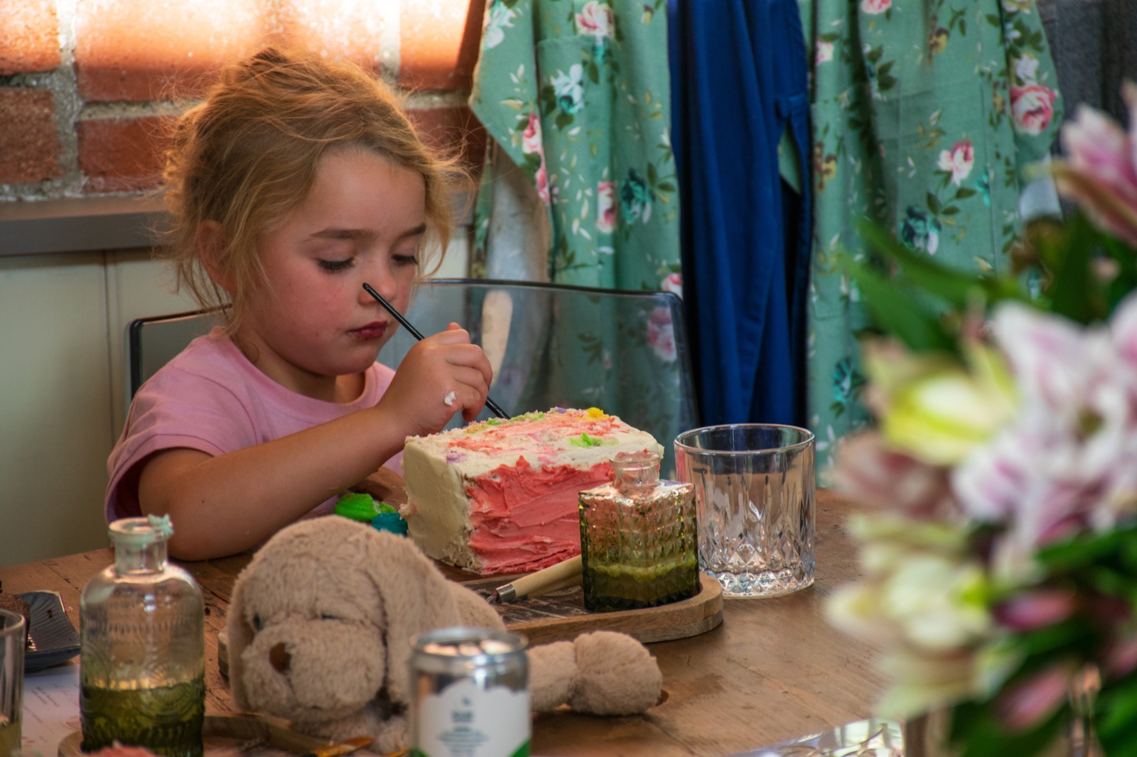 A young child concentrating while painting a cake