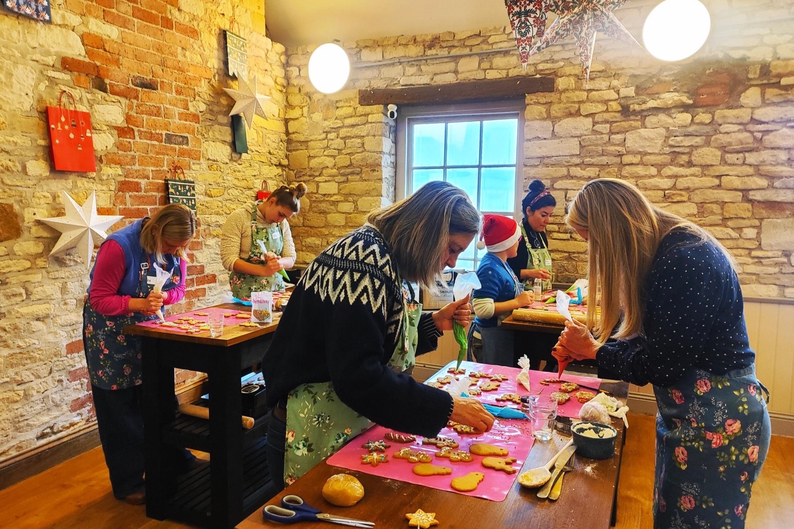 Guests icing festive biscuits around the workshop tables