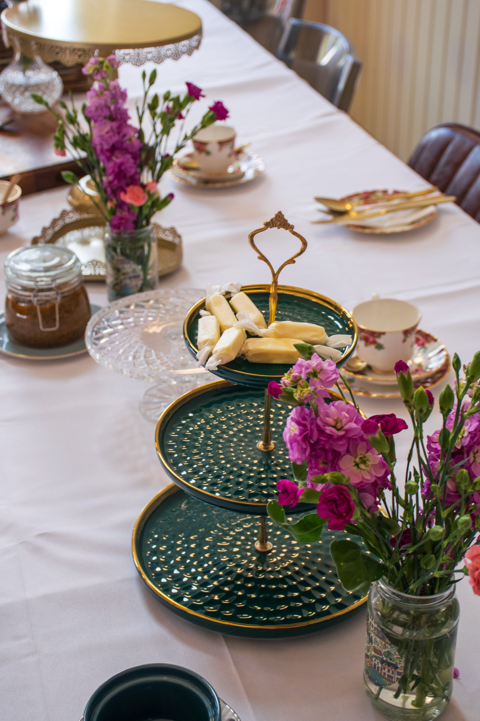 An afternoon tea stand with cakes, sandwiches and colourful macarons